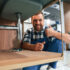 Showing thumb up and smiling. Plumber in blue uniform is at work in the bathroom indicating Memphis plumbing problem solved.