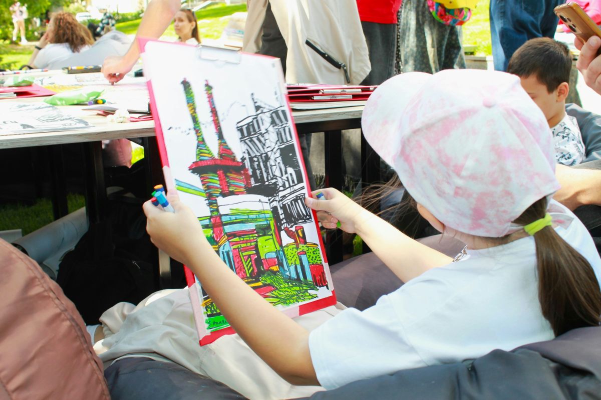 A young girl colorfully paints a picture