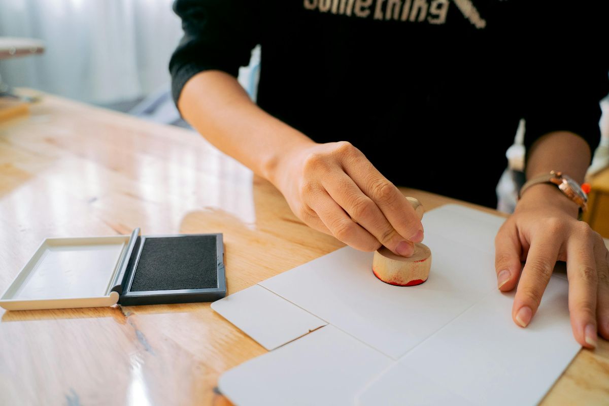 a person using a stamp and adding a mark to a paper